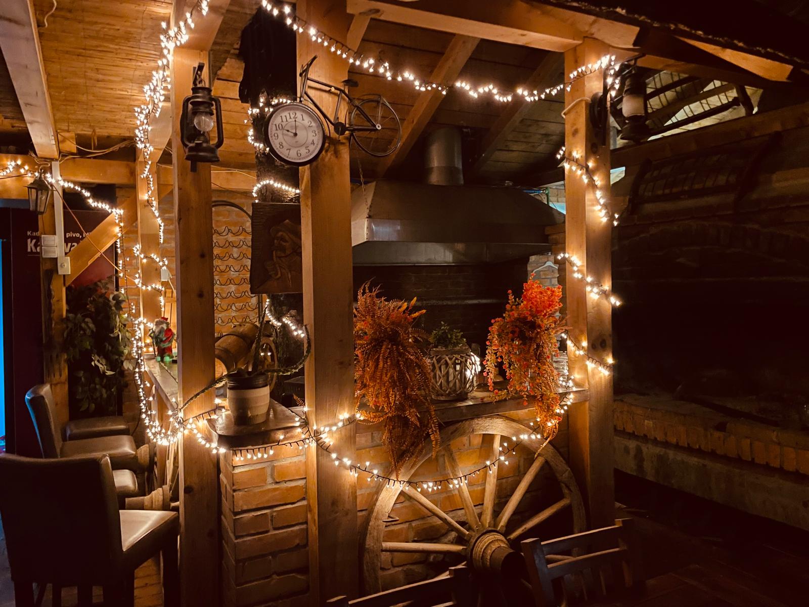 Konoba Petrić enterijer - rustikalna atmosfera s kamenom peći i tradicionalnim dekorom, Osijek